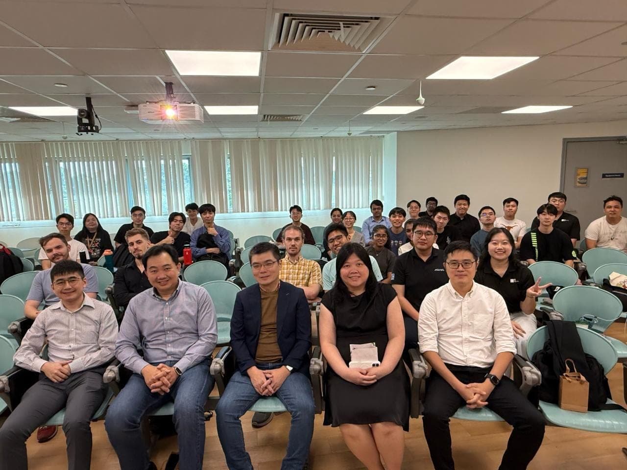Speakers seated in the front row with students behind them at the fireside chat