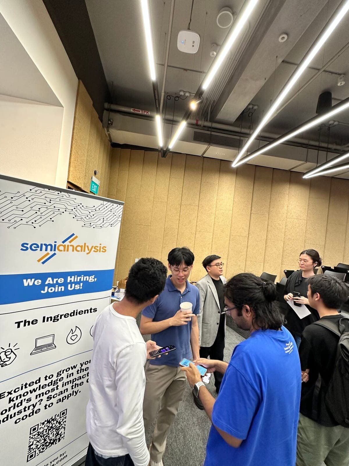 Students talking beside a SemiAnalysis pull-up banner after the session