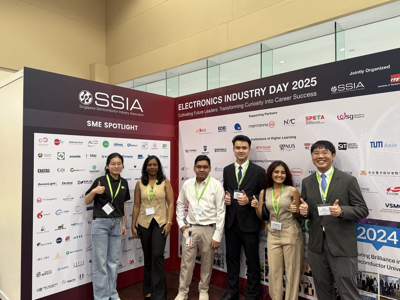 Six club members in front of the SSIA Electronics Industry Day 2025 backdrop