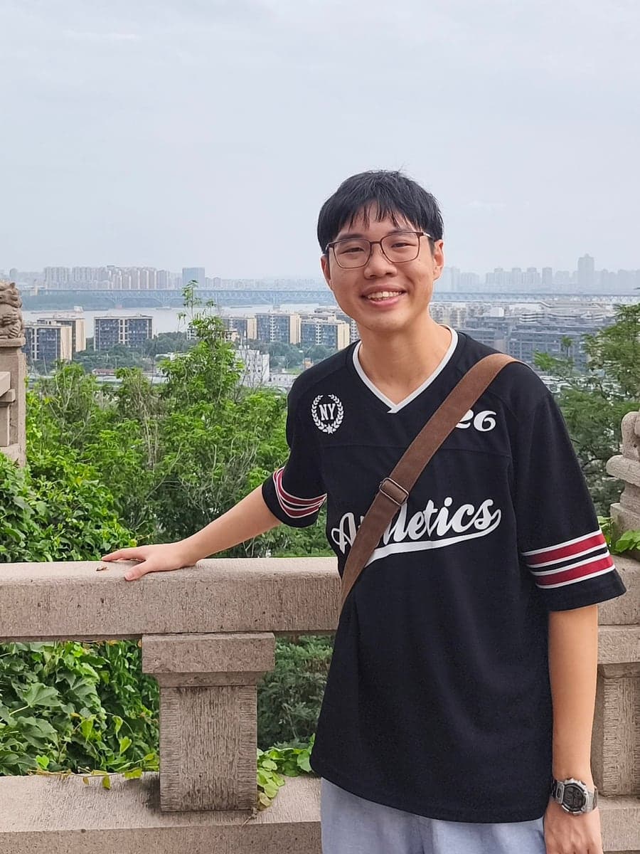 Ian Tay Rongde on a lookout over a river and city skyline