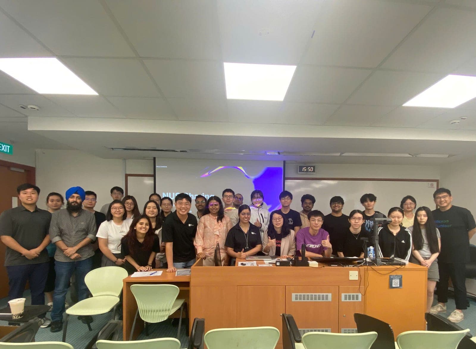Attendees and Micron staff gathered at the front of the seminar room at the end of the sharing session