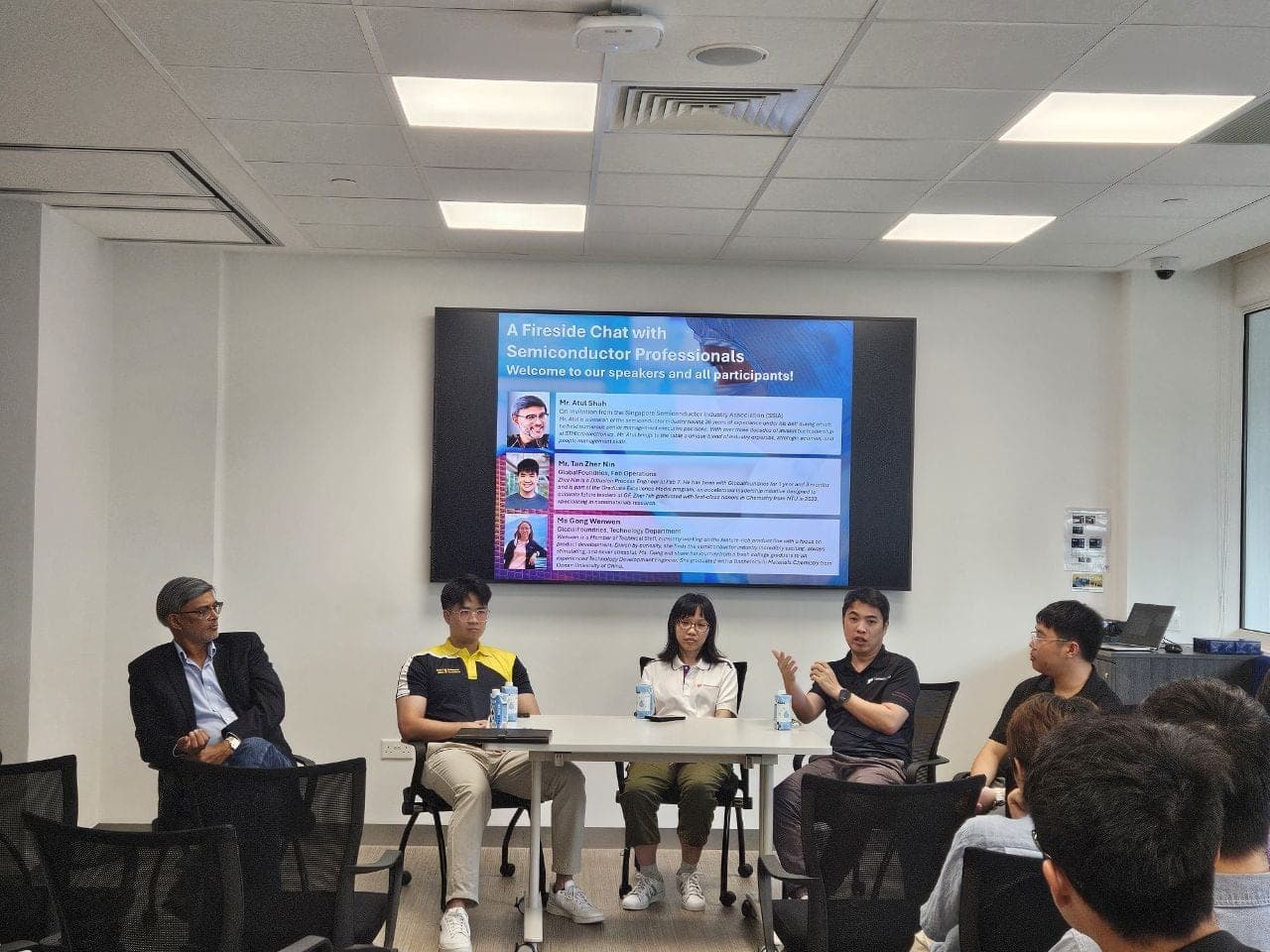 The panel seated in front of the speaker slide during the fireside chat, one of them mid-answer