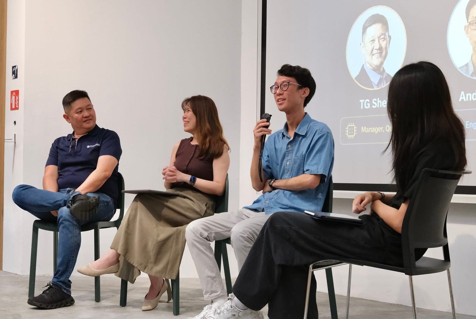 Four panellists seated during the Silicon Box fireside chat, one speaking into a microphone with the speaker slide projected behind them